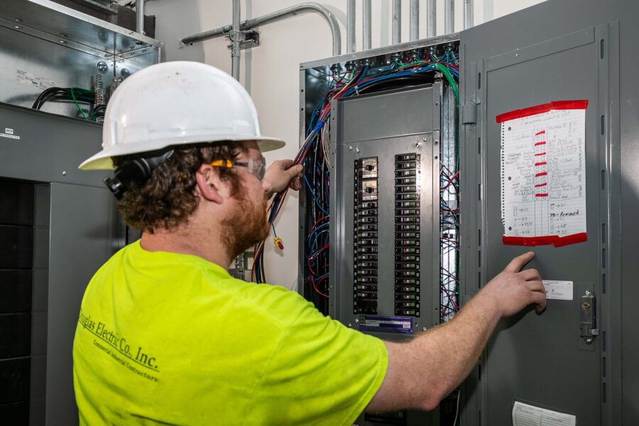 Douglas Electric electrician working on panel box